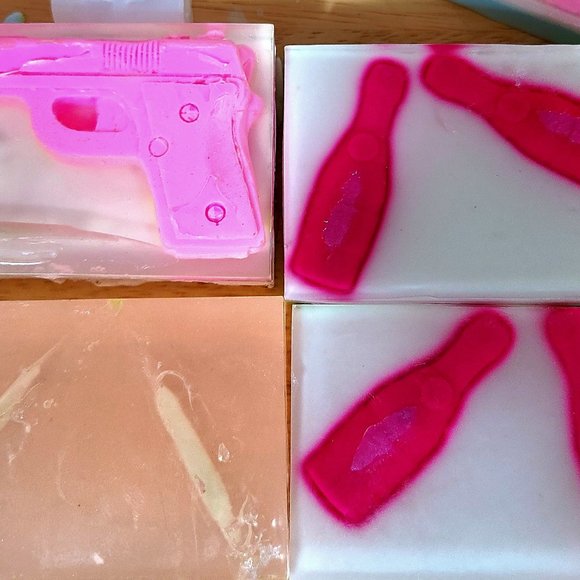 On the left is a pink Shea butter soap gun, under the gun is a clear glow bullet - Picture 1 of 3